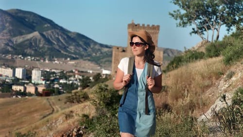 Attractive Backpacker Woman Enjoying Outdoor Activity Walking on Mountain Landscape at Sunset