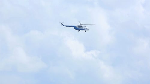 Helicopter Flying in Cloudy Blue Sky
