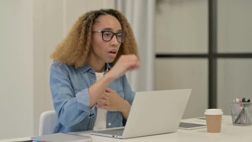Young Woman Coughing While Working on Laptop