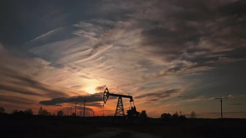 Oil Pump Silhouette Against Dramatic Sunset Sky