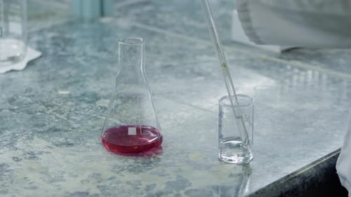 Der Bediener entnimmt eine Wasser- oder Lösungsprobe in einem Messrohr vor einem chemischen Indikator