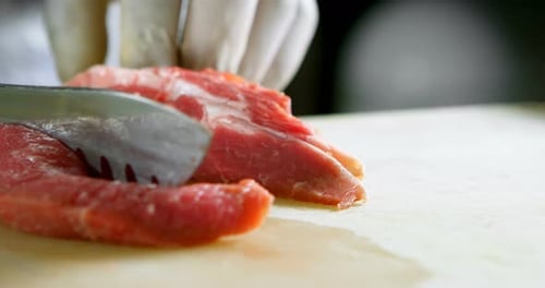 Butcher chopping meat in shop
