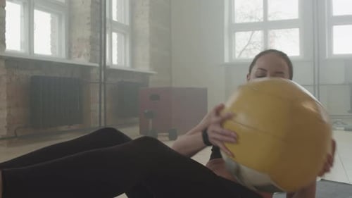 Une sportive fait des craquements latéraux avec un ballon de fitness