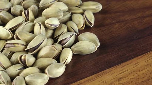Pile of Pistachios on a Dark Wood Table