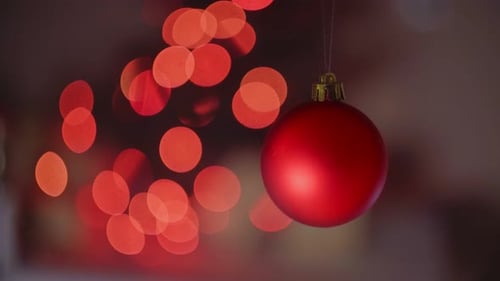 Red Christmas Bauble Hanging in Front of Bokeh Lights