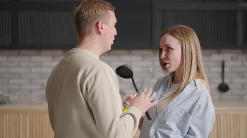 Couple Singing and Dancing with Kitchen Utensils