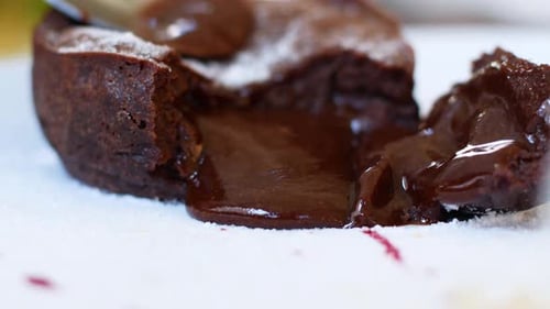 Mujeres comiendo pastel de chocolate en un café de verano. El chocolate líquido sale suavemente del pastel