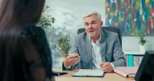 Entretien d'embauche Patron âgé aux cheveux gris assis au bureau en face de lui Femme postulant