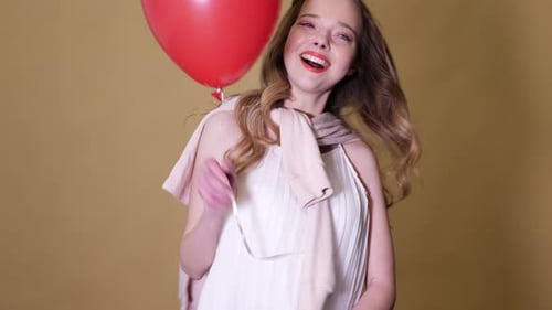 Smiling Woman Holding a Red Balloon