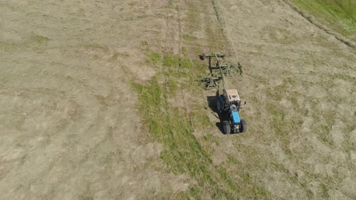 Trator com Rake Tedders no campo agrícola