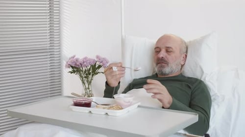Aged Man Having Meal in Hospital Ward