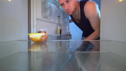 Man Checks Nearly Empty Refrigerator, Smells Onion