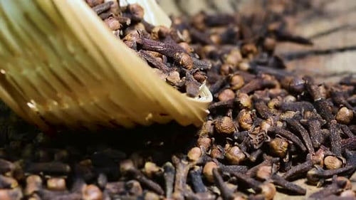 Aromatic Cloves in Small Basket on Wood Surface