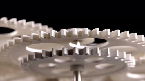 Rotating White Gears Against Black Background