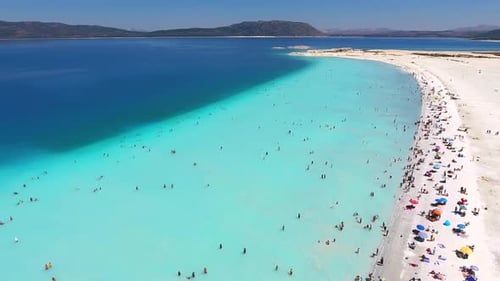 People Swim on Vacation in the White Sandy Beach of the Clear Tropical Turquoise Light Blue Sea