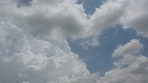 Fluffy White Clouds Moving Across a Blue Sky