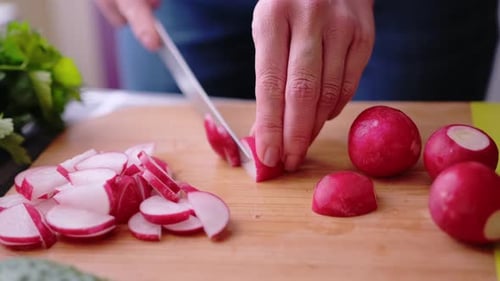 Radishes Being Chopped on a Wooden Board