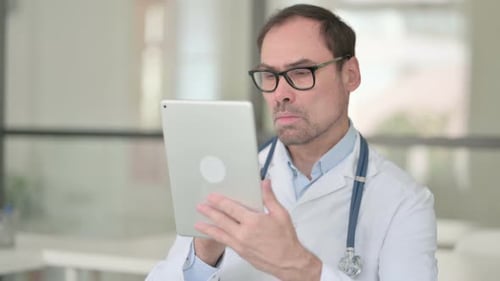 Doctor Holding Tablet While Standing Indoors