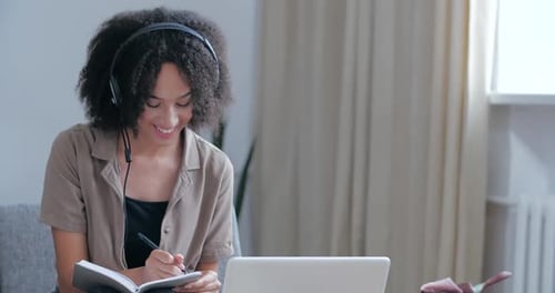 Woman with Laptop and Notebook Working at Home