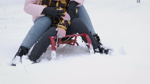 Mother and Daughter Share a Moment on a Sled