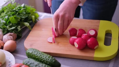Woman Slicing Radishes in Kitchen for Salad