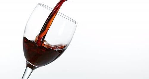 900055 Vinho tinto sendo derramado em vidro, contra fundo branco, câmera lenta 4K
