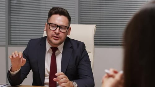 Man in Suit Speaking in an Office Setting