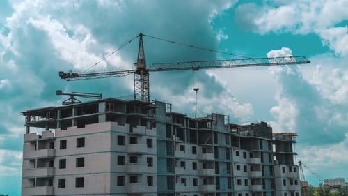 Time lapse. Working crane at the construction site. on the background of beautiful cloudy sky