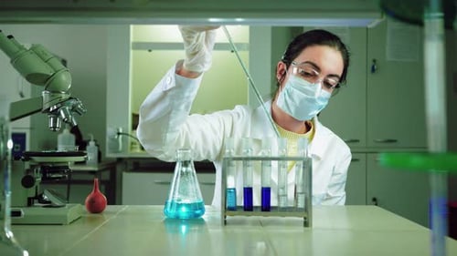 Female Scientist Works with Test Tubes in Laboratory