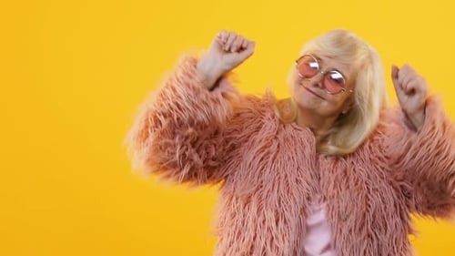 Happy Senior Woman Dancing on Yellow Background Slow Motion, Feeling Young Party
