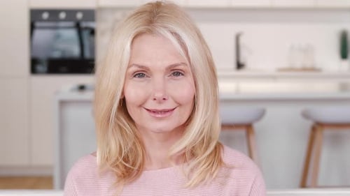 Mature Woman Smiling in Bright Kitchen Close Up