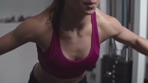 Woman Working Out in Gym on Weight Machine