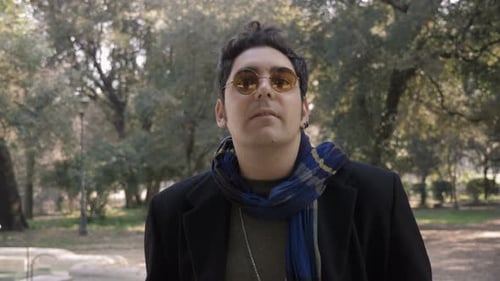 Relaxed handsome man walking in the park looking around