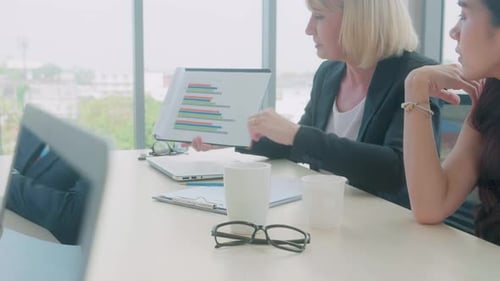 Groupe de gens d'affaires présentant un rapport de statistiques financières avec graphique et graphique.