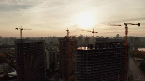 Construction Site with Cranes at Sunset. Construction of an Apartment Building.