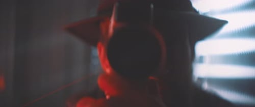 Front view of man looking into vintage camera in red lights