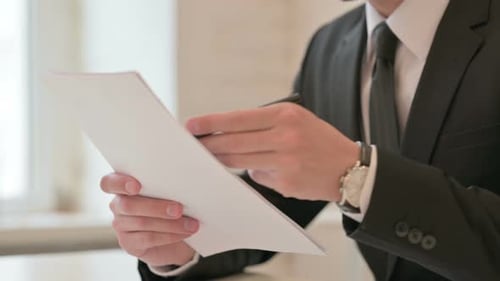 Close Up of Middle Aged Businessman Facing Failure While Studying Report