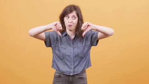 Woman Gives Two Thumbs Down Gesture in Studio