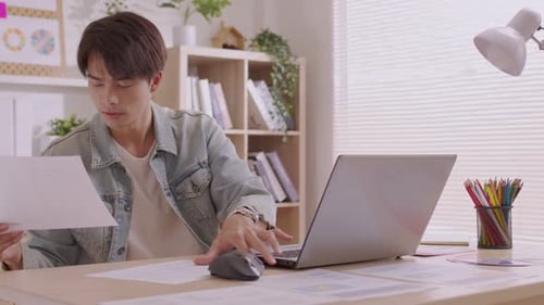 Young Adult Working at a Laptop in Home Office