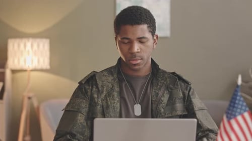 Young Adult in Military Jacket Working at Home