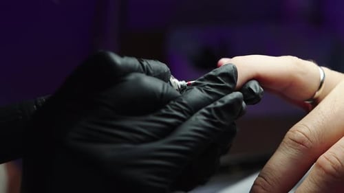 Hardware Manicure - Master reinigt den Nagel mit einem kleinen Nagelschleifer aus der Nagelhaut