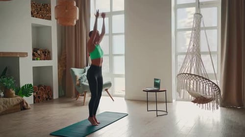 Woman Doing Fitness Exercise Jumping with Help Her Instructor Online on Laptop