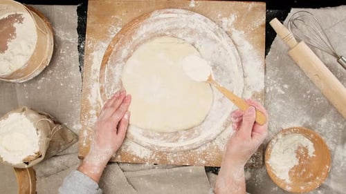 Hands Prepare Pizza Dough with Flour and Spoon