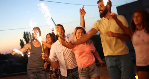 Young Adults Celebrate with Sparklers at Rooftop Party