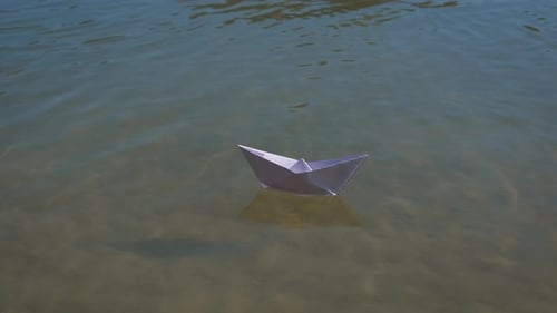 Paper Boat Drifting Peacefully in Water
