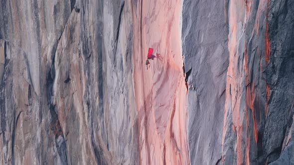 Mountain Climber Hanging on Rope on El Capitan Mountain at Red Orange