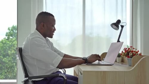 Man Working on Laptop Computer at Desk Indoors