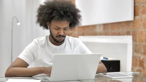 Young Adult Working on Laptop at Office Desk