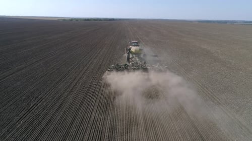Farming, Seeding Machine with Plow Sows Grain in Soil of Field at Planting Season at Spring