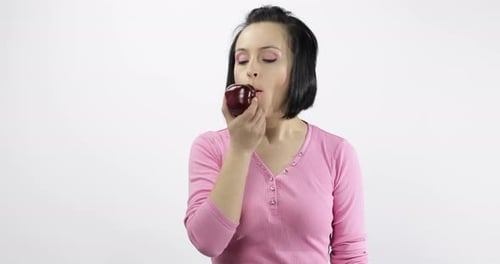 Woman Bites Into Red Apple and Offers it